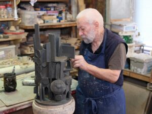 Artisan métallier réalisant une démonstration de sculpture en métal devant un public