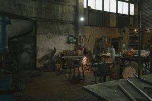 Artisan soudant une sculpture en métal recyclé dans un atelier
